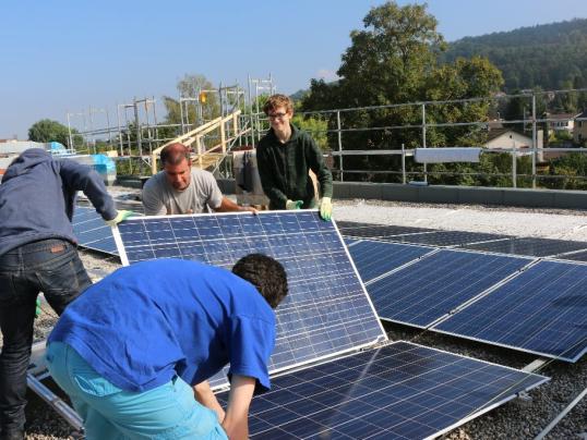 Schülerinnen und Schüler installieren ein Kraftwerk auf ihrem Schulhaus